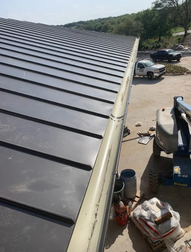 Standing seam panel and gutter detail on a metal roofing jobsite in Satsuma